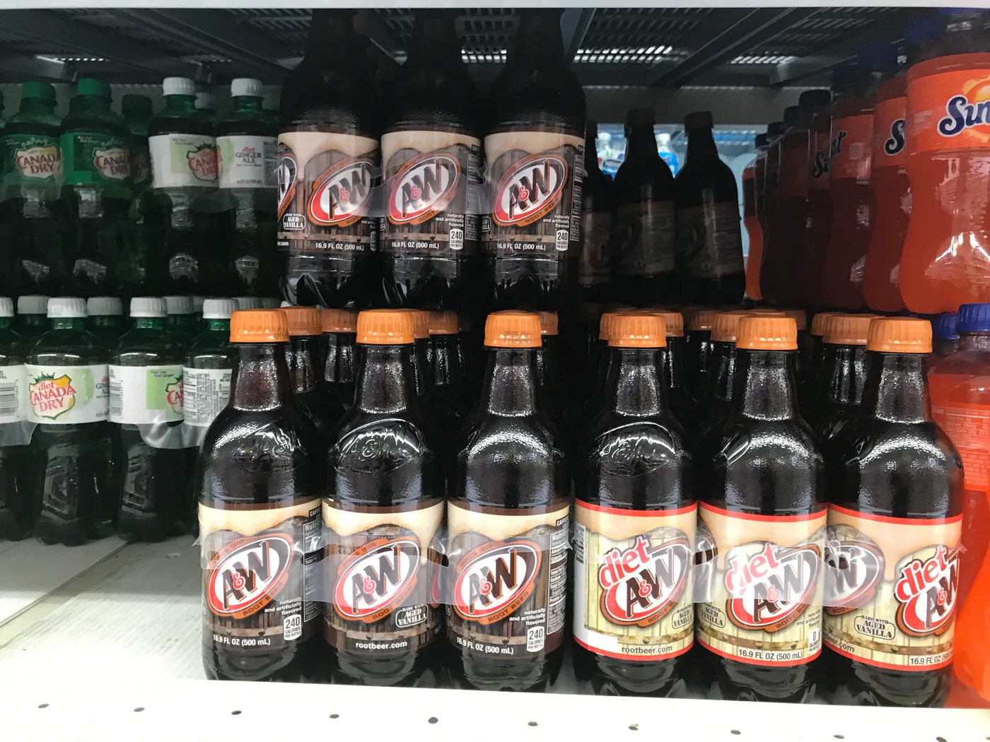 A&W Root Beer und Diet A&W nebeneinander im Kühlregal eines US-Supermarkts, daneben Canada Dry und Sunkist