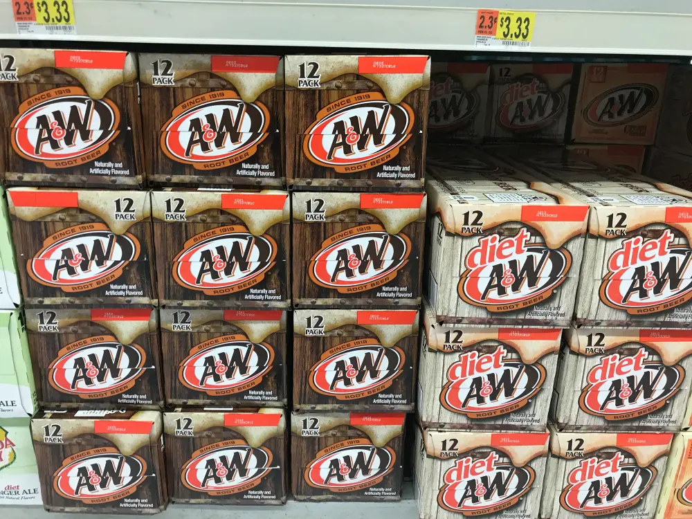 Regal in einem US-Supermarkt voller Zwölferkartons A&W Root Beer und Diet A&W, darüber ein Preisschild mit 2 für 3,33 Dollar