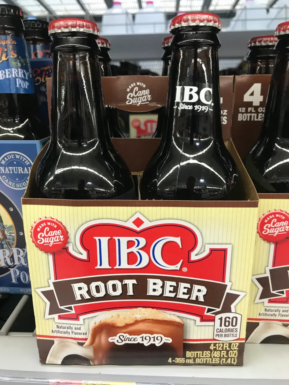 Viererpack IBC Root Beer in braunen Glasflaschen im Regal eines US-Supermarkts, Aufschrift Made with Cane Sugar und Since 1919